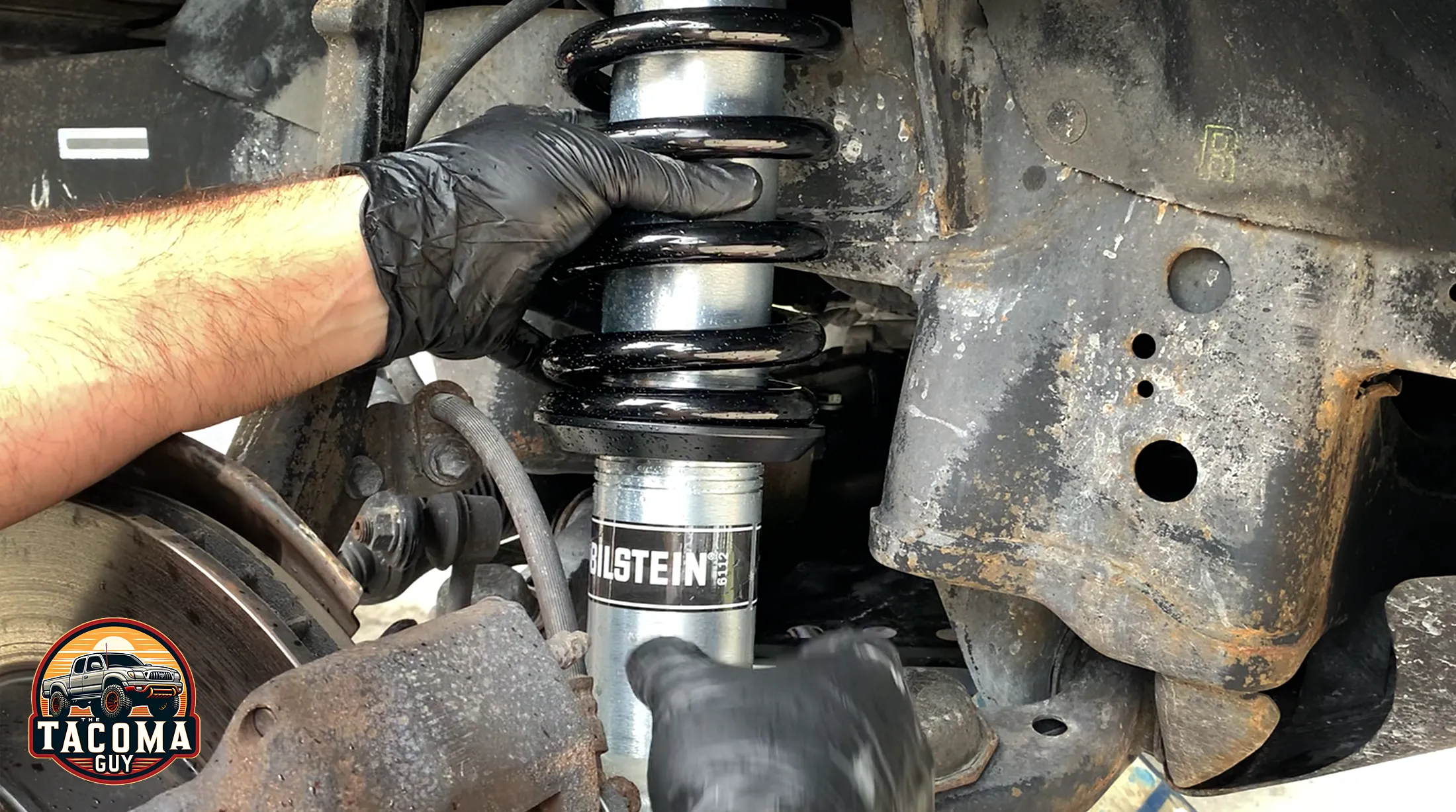 New Bilstein 6112 shock and strut assembly being installed on a 2003 toyota tacoma