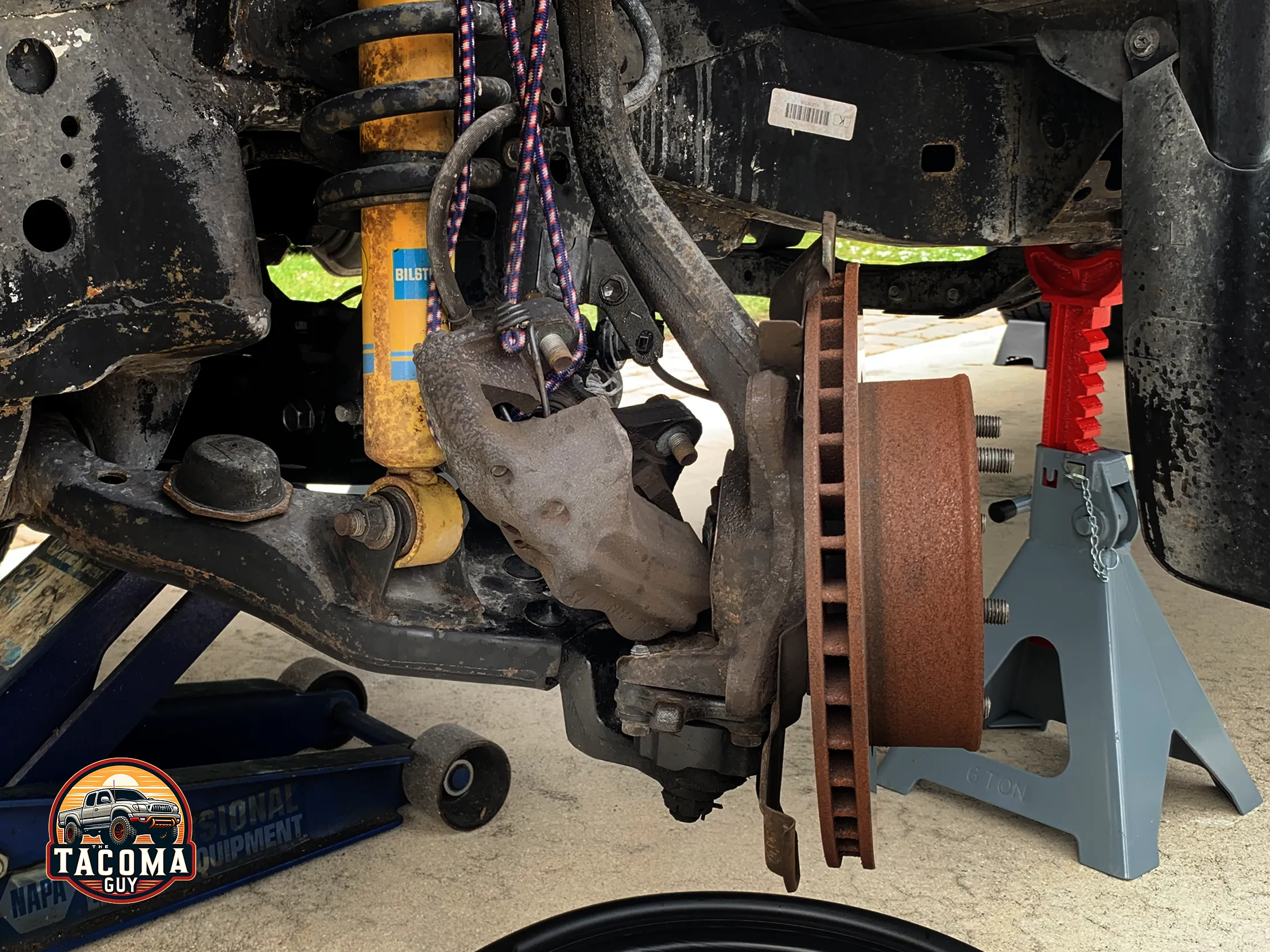 Gen 1 Tacoma hanging caliper on the lower control arm while changing the rotor. 