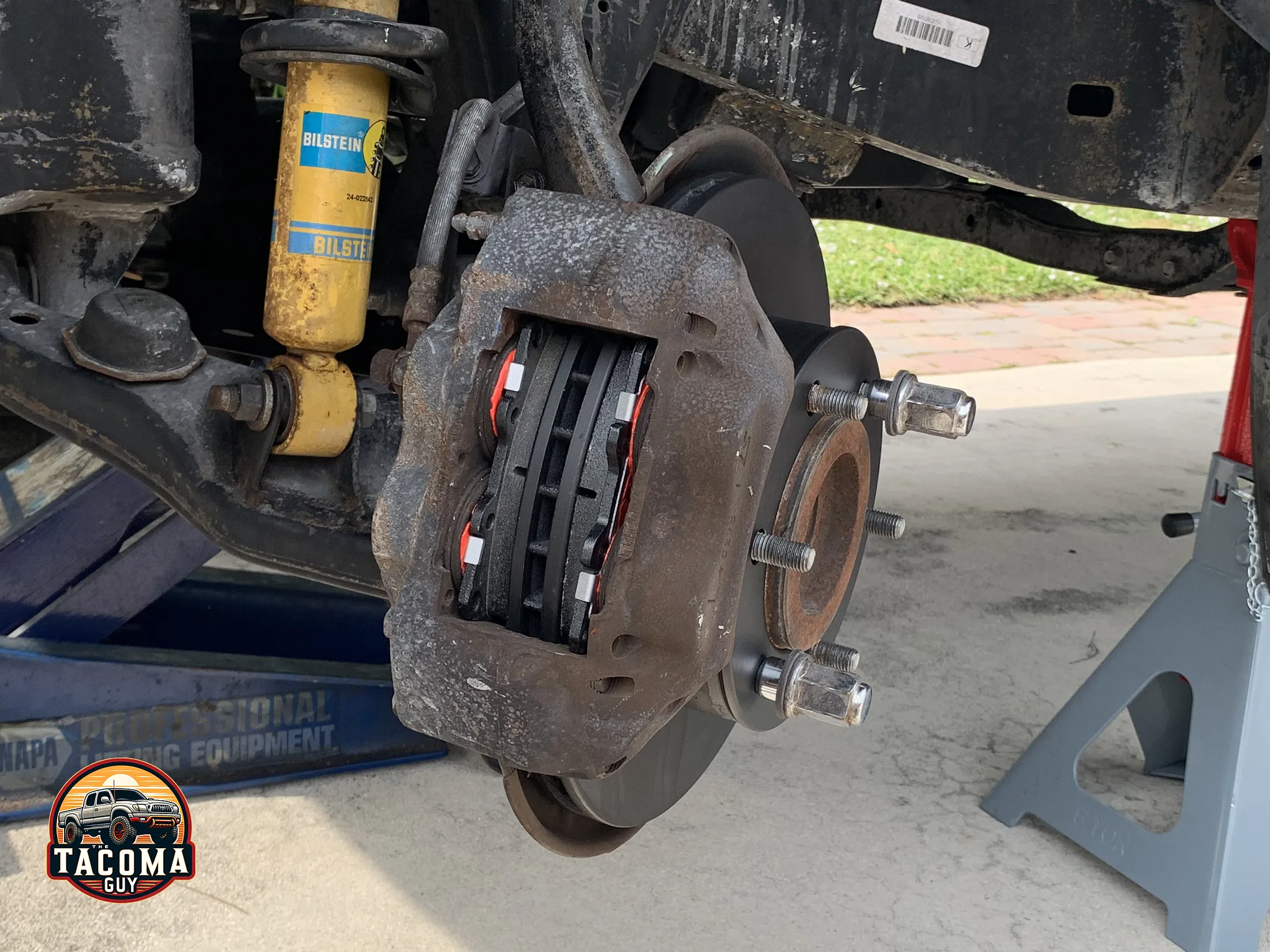 A close-up of new brake pads and new rotor on a gen 1 toyota tacoma