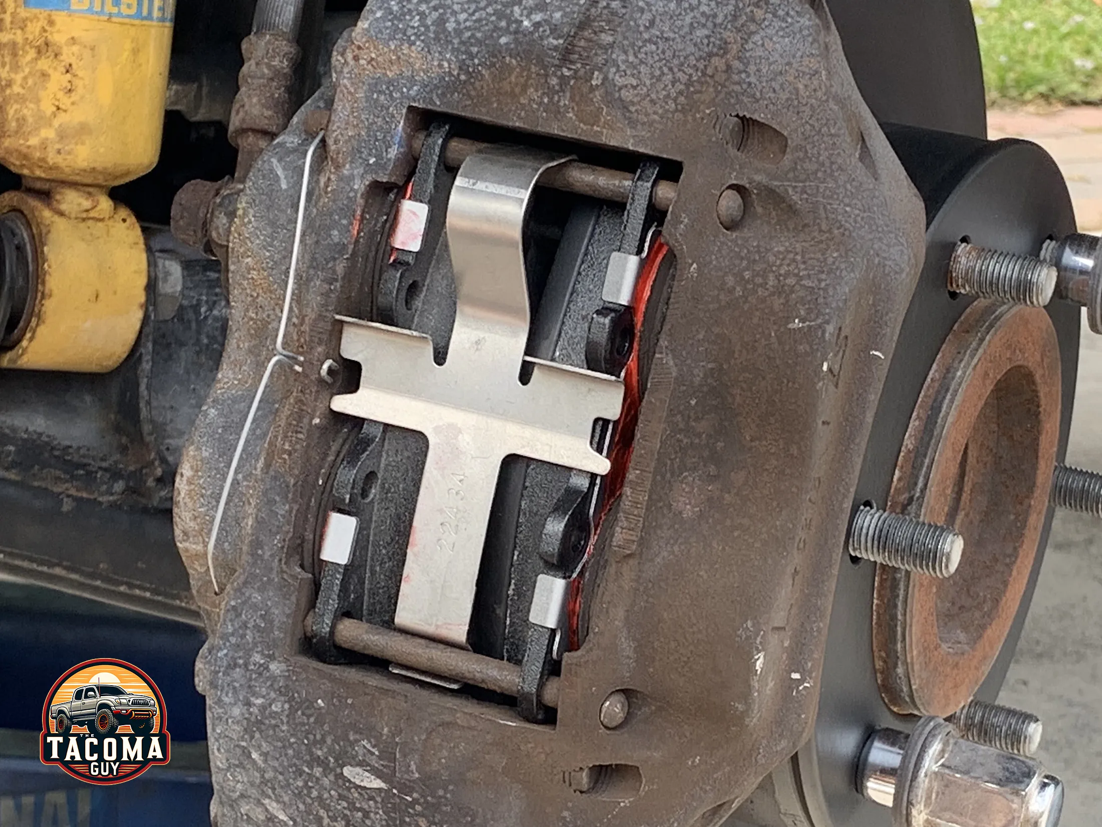 Close-up of a gen 1 tacoma brake caliper and pads