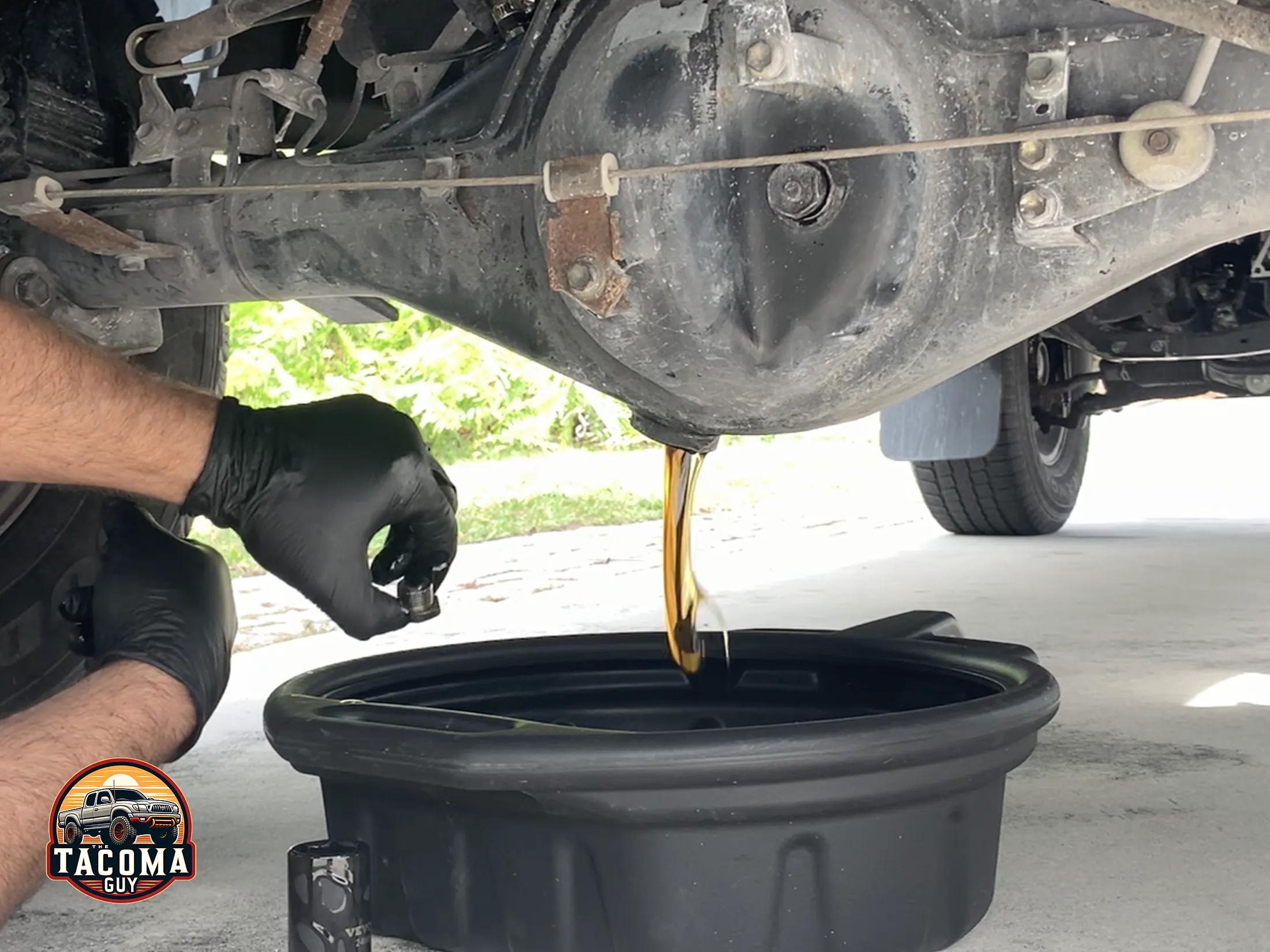 Gear oil draining from the bottom of a rear differential of a gen 1 toyota tacoma